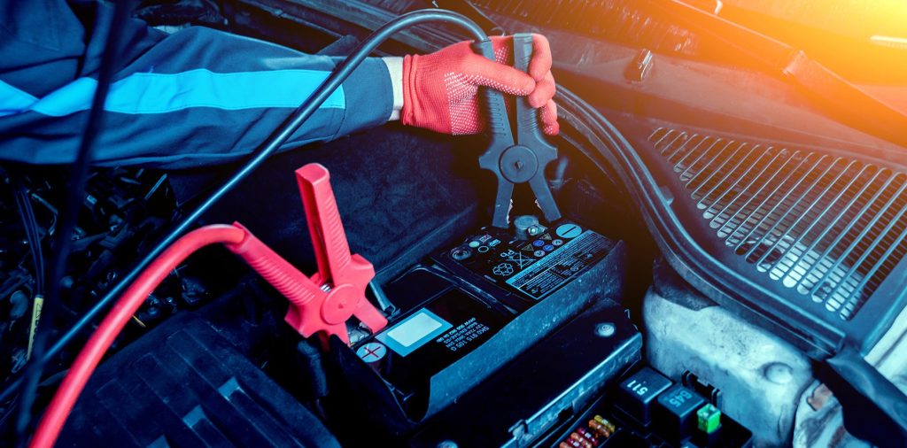An image of jumper cables being affixed to a car battery.