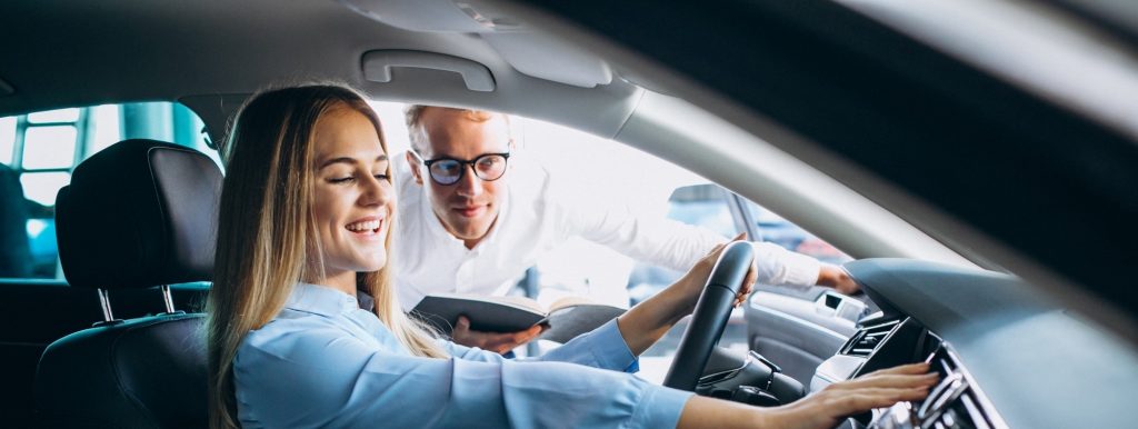 Happy young driver sitting at the steering wheel of Ford